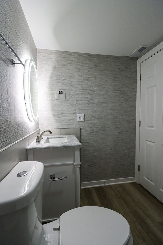 bathroom with vanity, hardwood / wood-style floors, and toilet