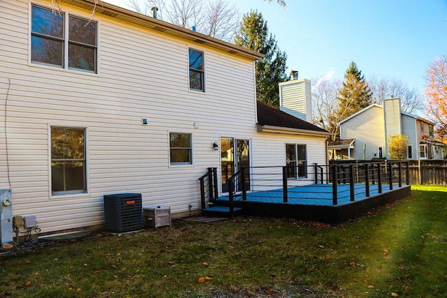 rear view of house featuring a wooden deck, a yard, and central AC