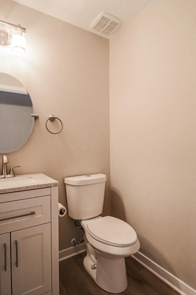 bathroom featuring vanity, wood-type flooring, and toilet