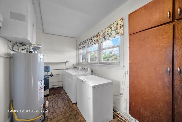 laundry room featuring washing machine and clothes dryer, water heater, and cabinets