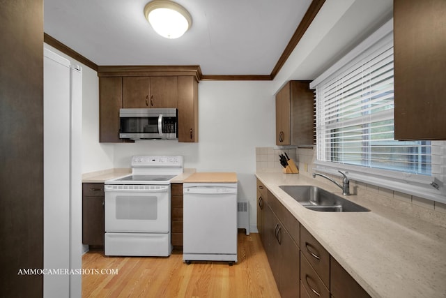 kitchen featuring dishwasher, backsplash, sink, light hardwood / wood-style flooring, and range with electric stovetop