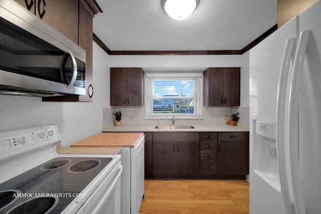 kitchen with sink, tasteful backsplash, crown molding, light hardwood / wood-style floors, and white appliances