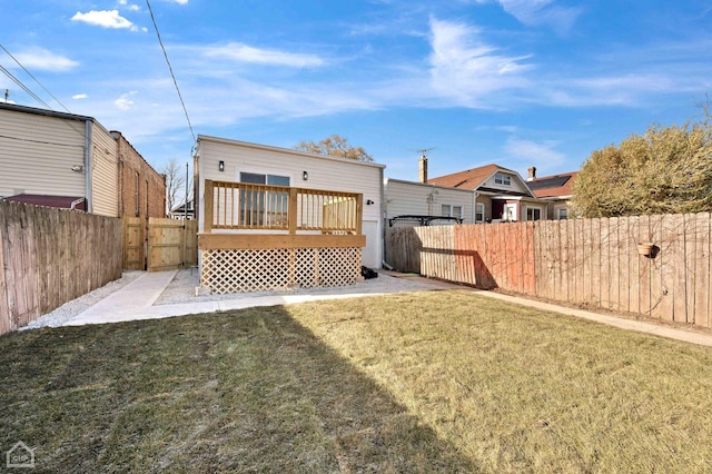 rear view of house with a lawn and a wooden deck