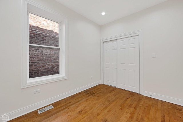 unfurnished bedroom with a closet and hardwood / wood-style flooring