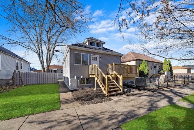 bungalow featuring a front yard and a wooden deck