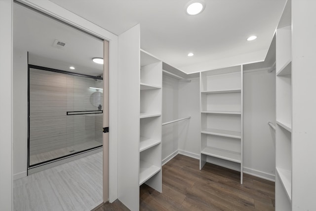 spacious closet with dark hardwood / wood-style flooring