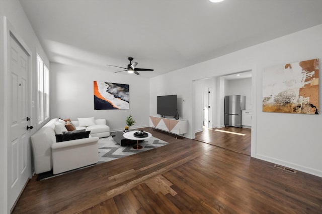 living room with ceiling fan and dark wood-type flooring