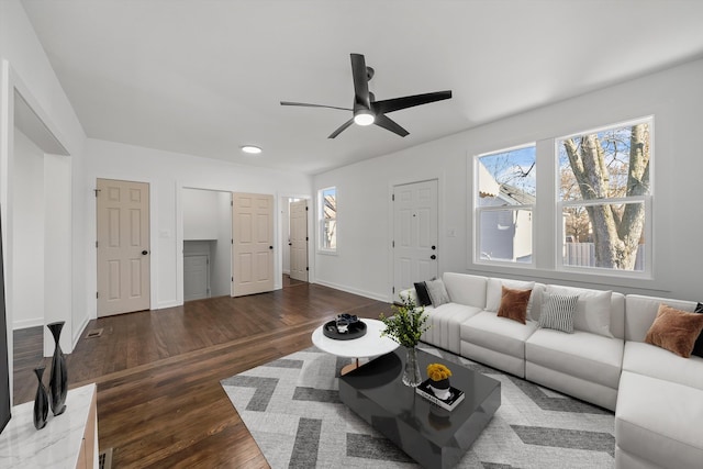 living room featuring ceiling fan and dark wood-type flooring