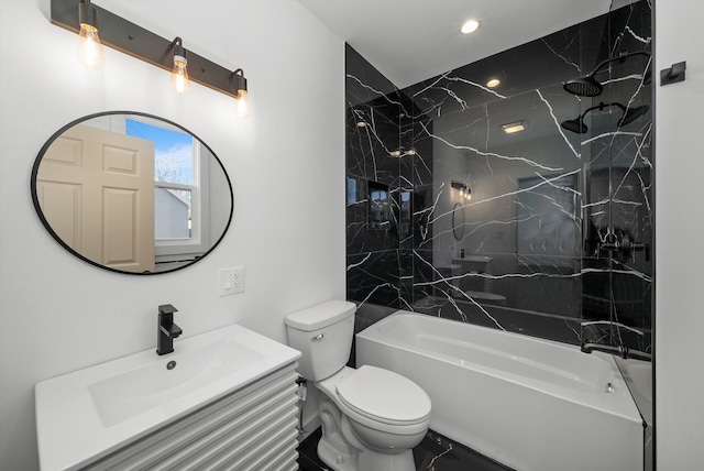 full bathroom featuring tiled shower / bath combo, toilet, and vanity