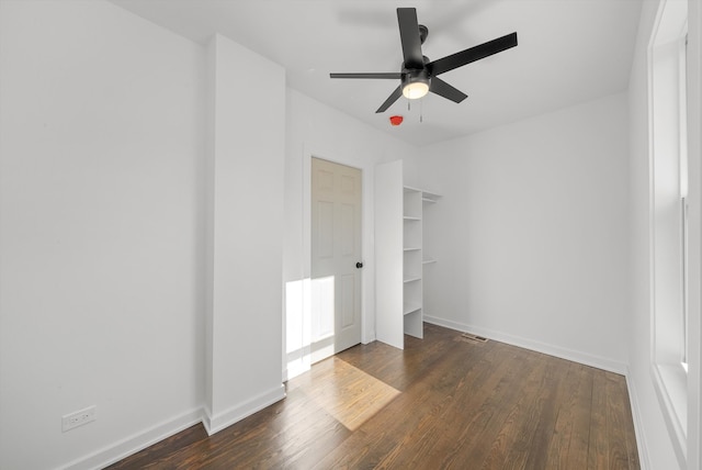 unfurnished bedroom featuring ceiling fan, a closet, and dark wood-type flooring