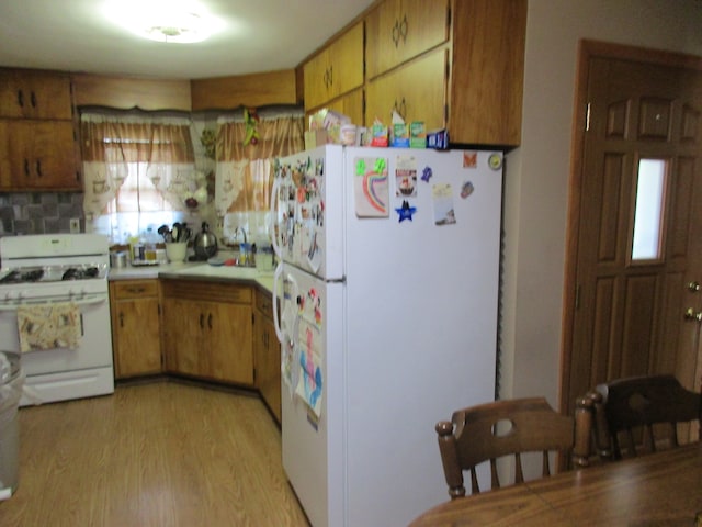 kitchen featuring decorative backsplash, white appliances, and light hardwood / wood-style flooring