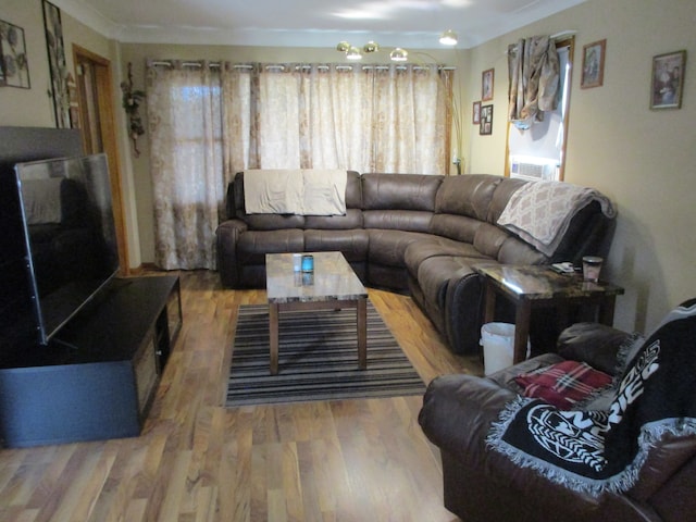 living room featuring cooling unit, wood-type flooring, and crown molding