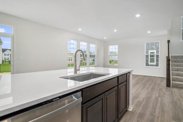 kitchen with dark brown cabinetry, dishwasher, light hardwood / wood-style flooring, and sink