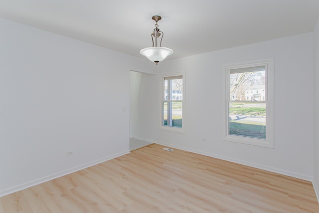 empty room with a healthy amount of sunlight and light hardwood / wood-style flooring