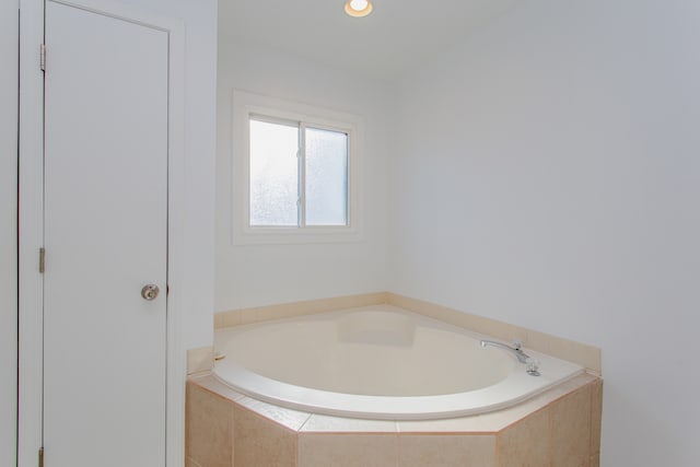 bathroom with a relaxing tiled tub