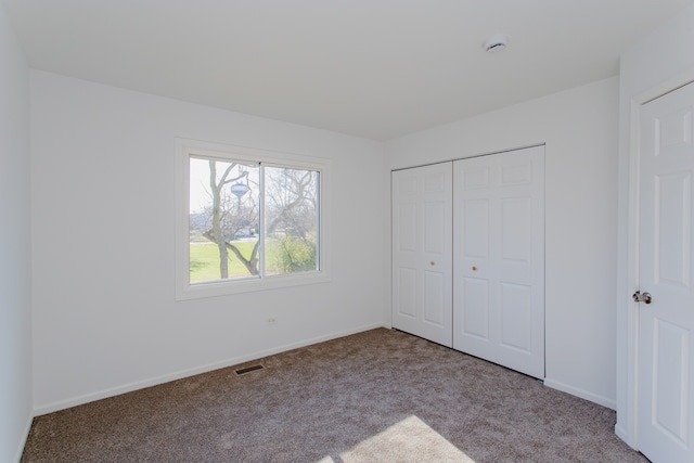 unfurnished bedroom featuring light colored carpet and a closet