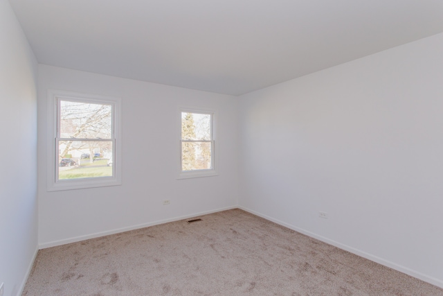 empty room featuring light colored carpet and plenty of natural light