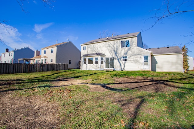 rear view of property with a yard