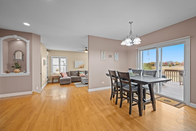 dining space featuring ceiling fan with notable chandelier and light wood-type flooring