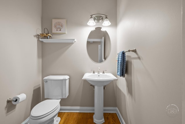 bathroom with toilet and wood-type flooring