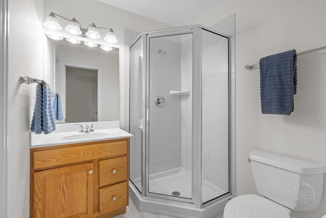 bathroom featuring tile patterned floors, vanity, toilet, and a shower with door