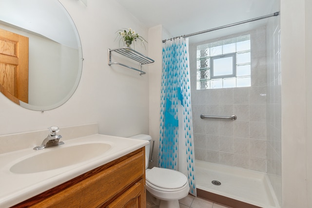 bathroom with toilet, tile patterned flooring, vanity, and walk in shower