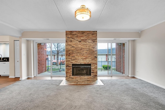 unfurnished living room featuring crown molding, plenty of natural light, and a fireplace