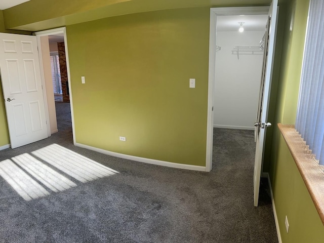 spare room with dark carpet