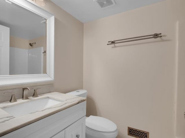 bathroom with vanity, a shower, and toilet