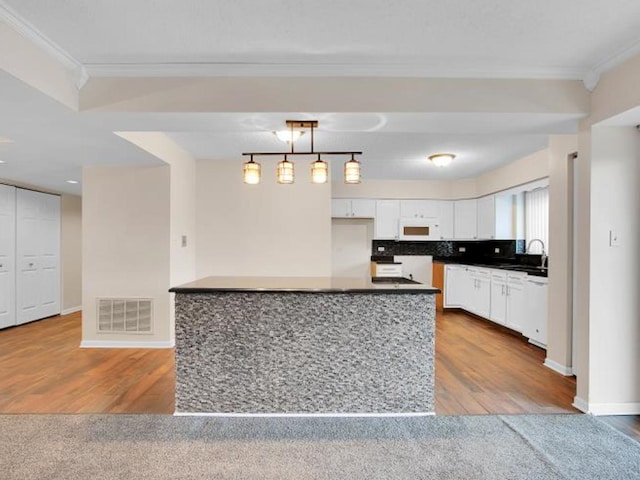 kitchen with decorative light fixtures, white cabinets, decorative backsplash, ornamental molding, and white appliances