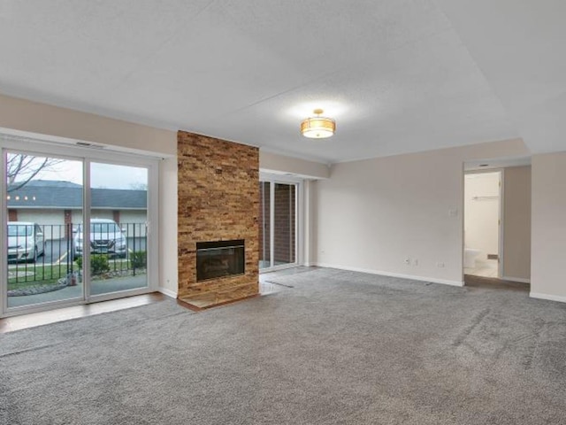 unfurnished living room featuring a large fireplace and carpet flooring