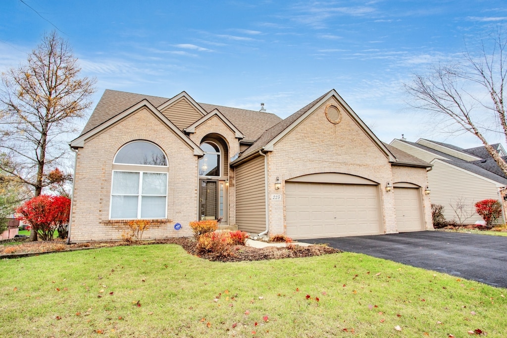 view of front of property featuring a front yard and a garage