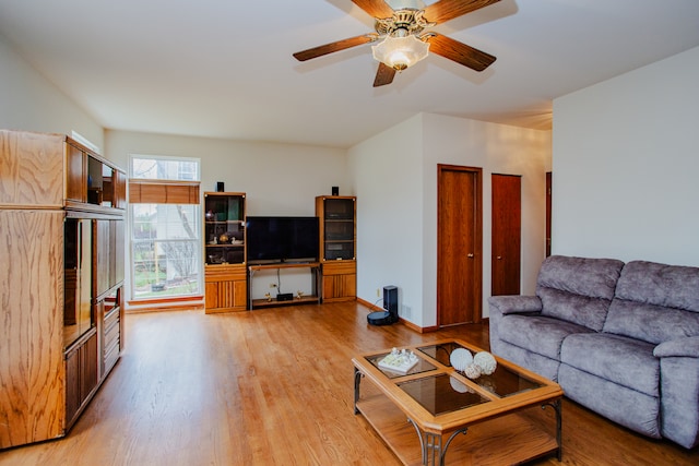 living room with light hardwood / wood-style floors and ceiling fan