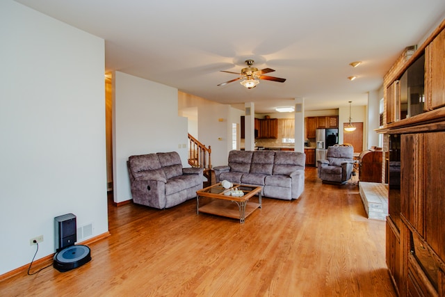 living room with light wood-type flooring and ceiling fan