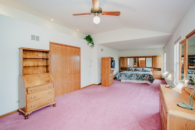 carpeted bedroom with ceiling fan, a closet, and vaulted ceiling