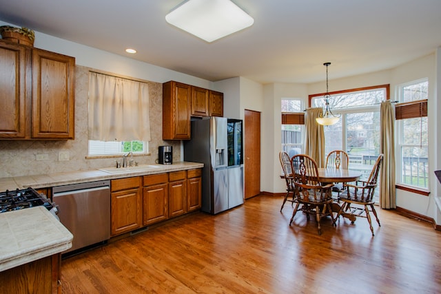 kitchen featuring hardwood / wood-style floors, a healthy amount of sunlight, sink, and appliances with stainless steel finishes