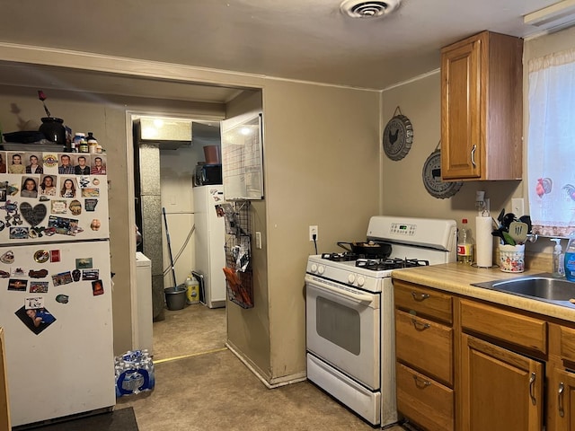 kitchen featuring water heater, sink, and white appliances