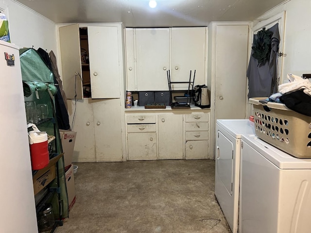 clothes washing area with cabinets and washing machine and dryer