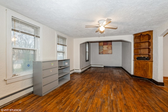 unfurnished room with a textured ceiling, dark hardwood / wood-style floors, ceiling fan, and a baseboard heating unit