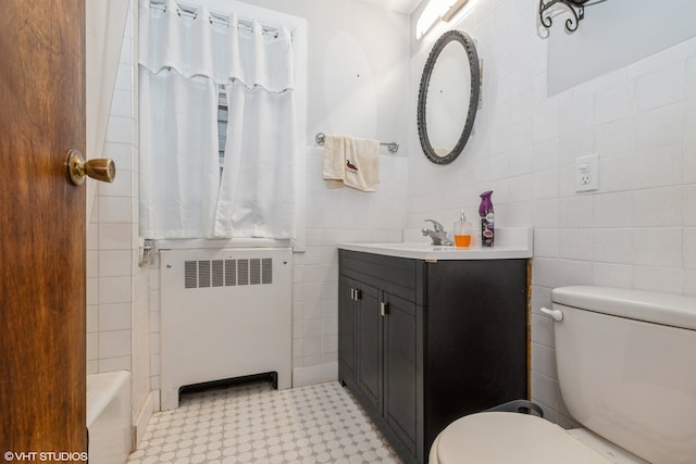 full bathroom with shower / bath combination with curtain, radiator, vanity, tile walls, and toilet