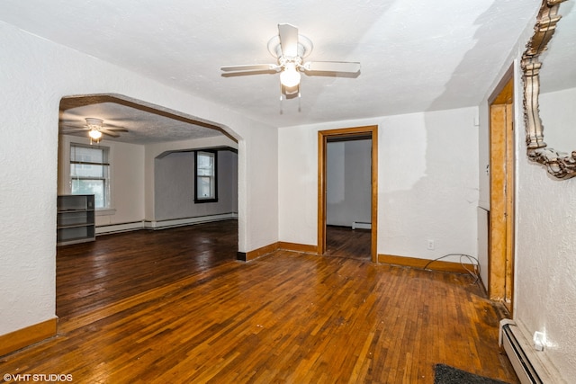 unfurnished room with baseboard heating and dark wood-type flooring