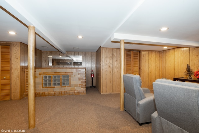 basement with a fireplace, wood walls, and light carpet