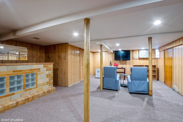 basement featuring wood walls, light carpet, and indoor bar