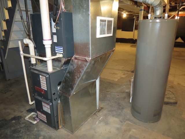 utility room with heating unit and gas water heater