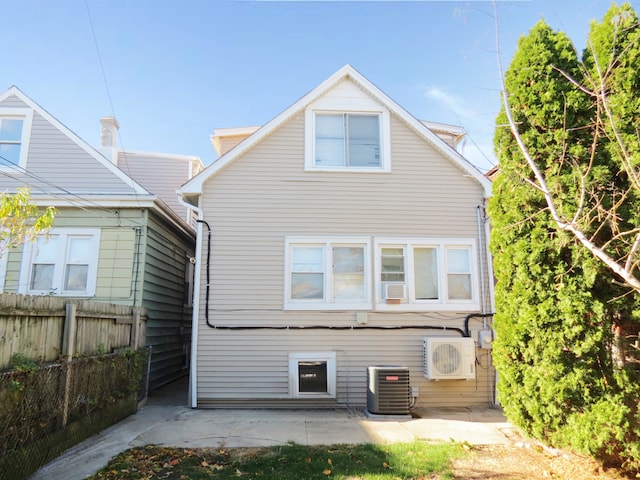 back of property with central AC, ac unit, and a patio