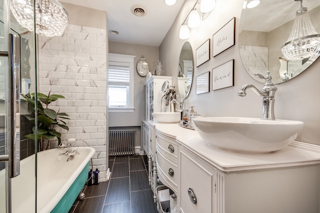 bathroom with a washtub, radiator heating unit, vanity, and an inviting chandelier