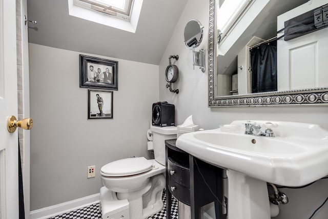 bathroom featuring vaulted ceiling with skylight, tile patterned flooring, toilet, and a shower with shower curtain