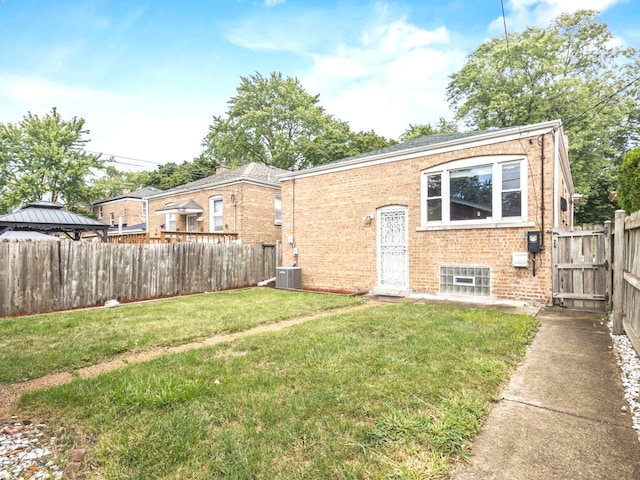 exterior space featuring central AC unit and a front lawn