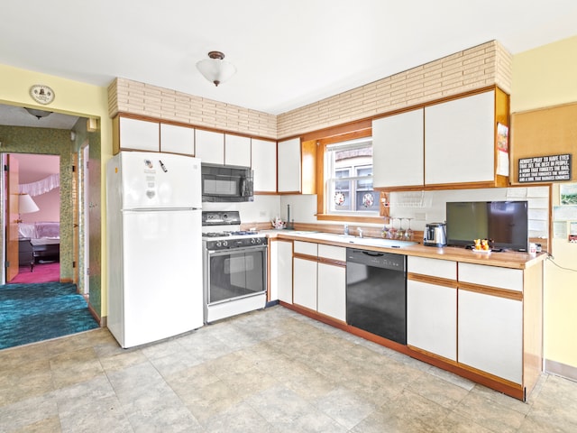 kitchen featuring black appliances and white cabinetry