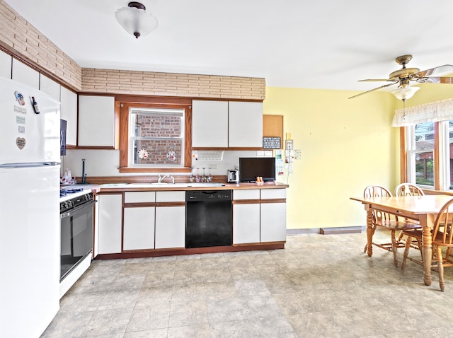 kitchen featuring white cabinets, brick wall, gas range, dishwasher, and white fridge